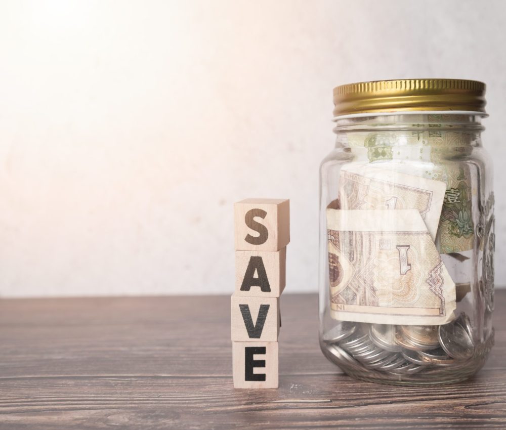 glass-jar-savings-with-wooden-word